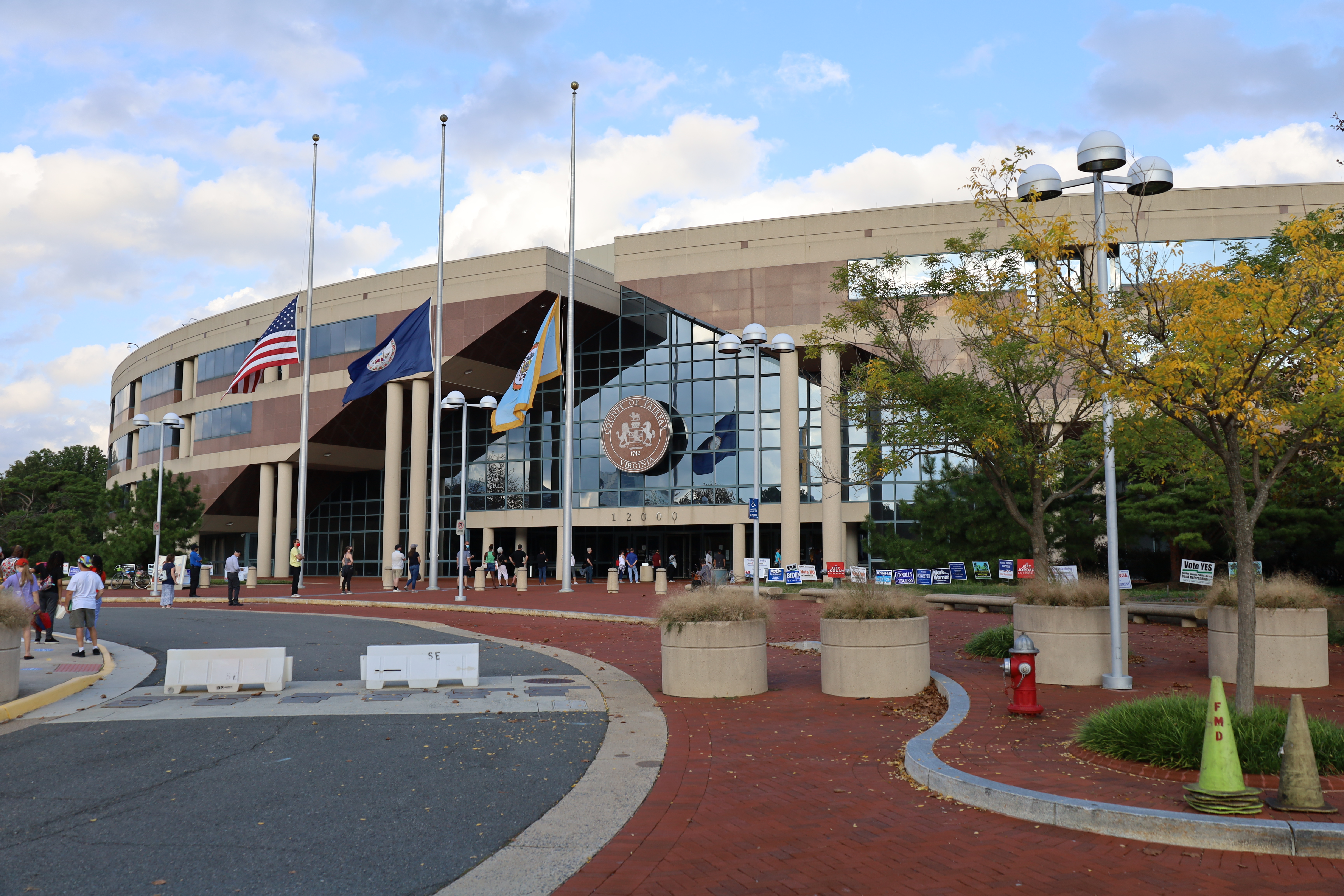 Exterior of the Fairfax County Government Center with flags and a circular driveway.