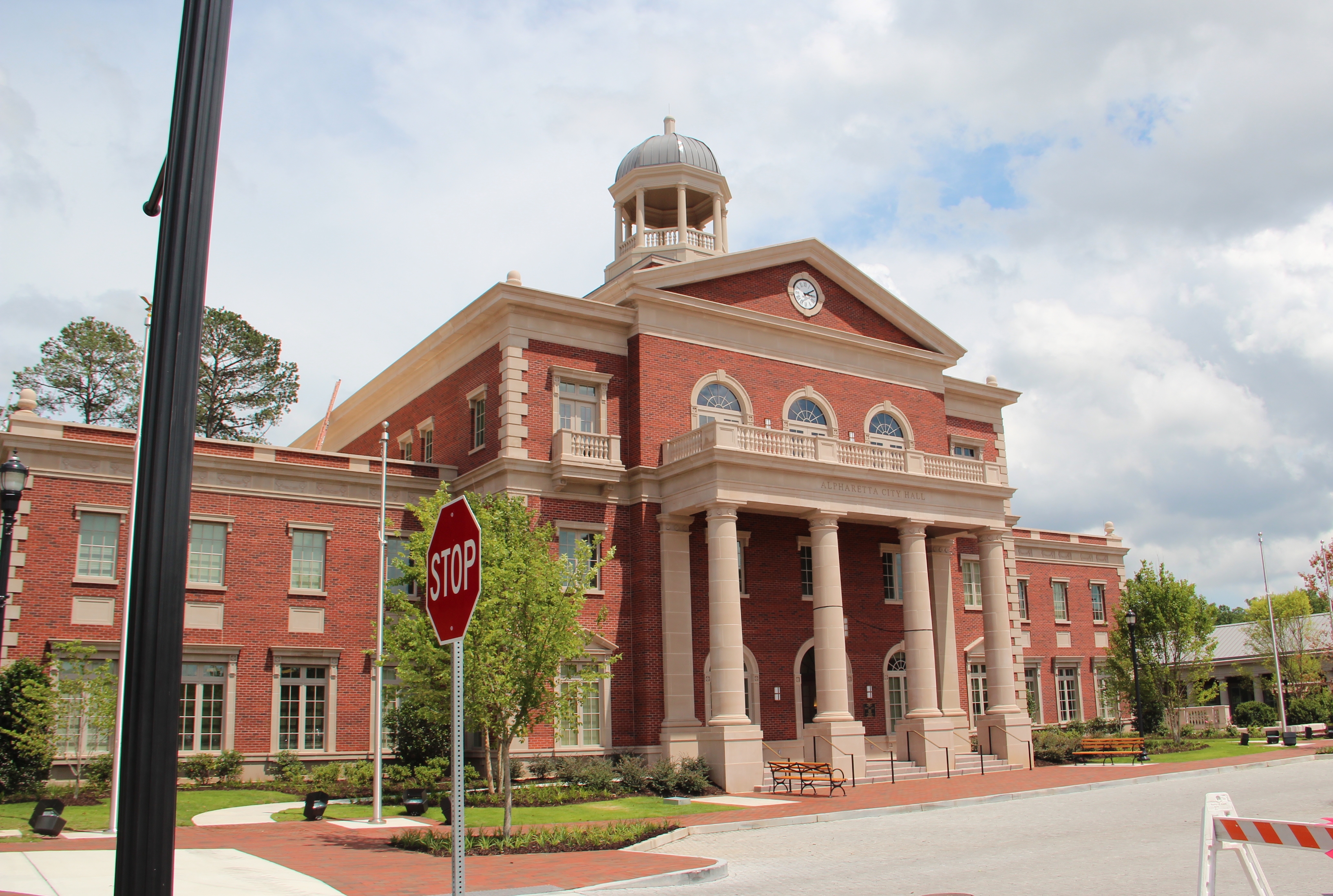 Red brick government building with a cupola and columned entrance portico.