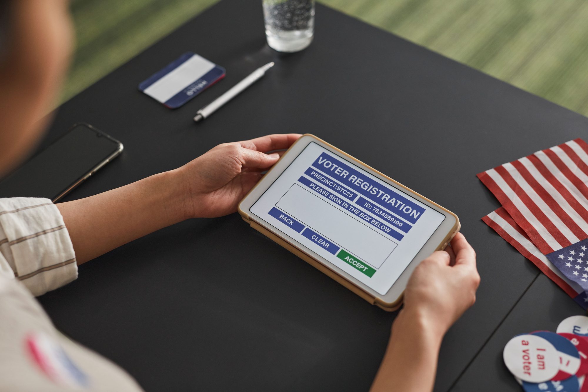 A person using a tablet for voter registration, highlighting digital voting processes.