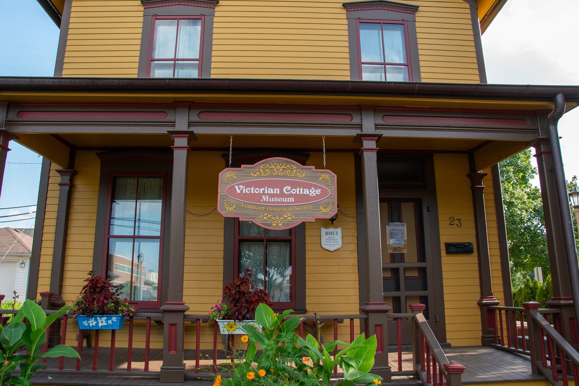Yellow two-story Victorian house with covered porch and museum sign.