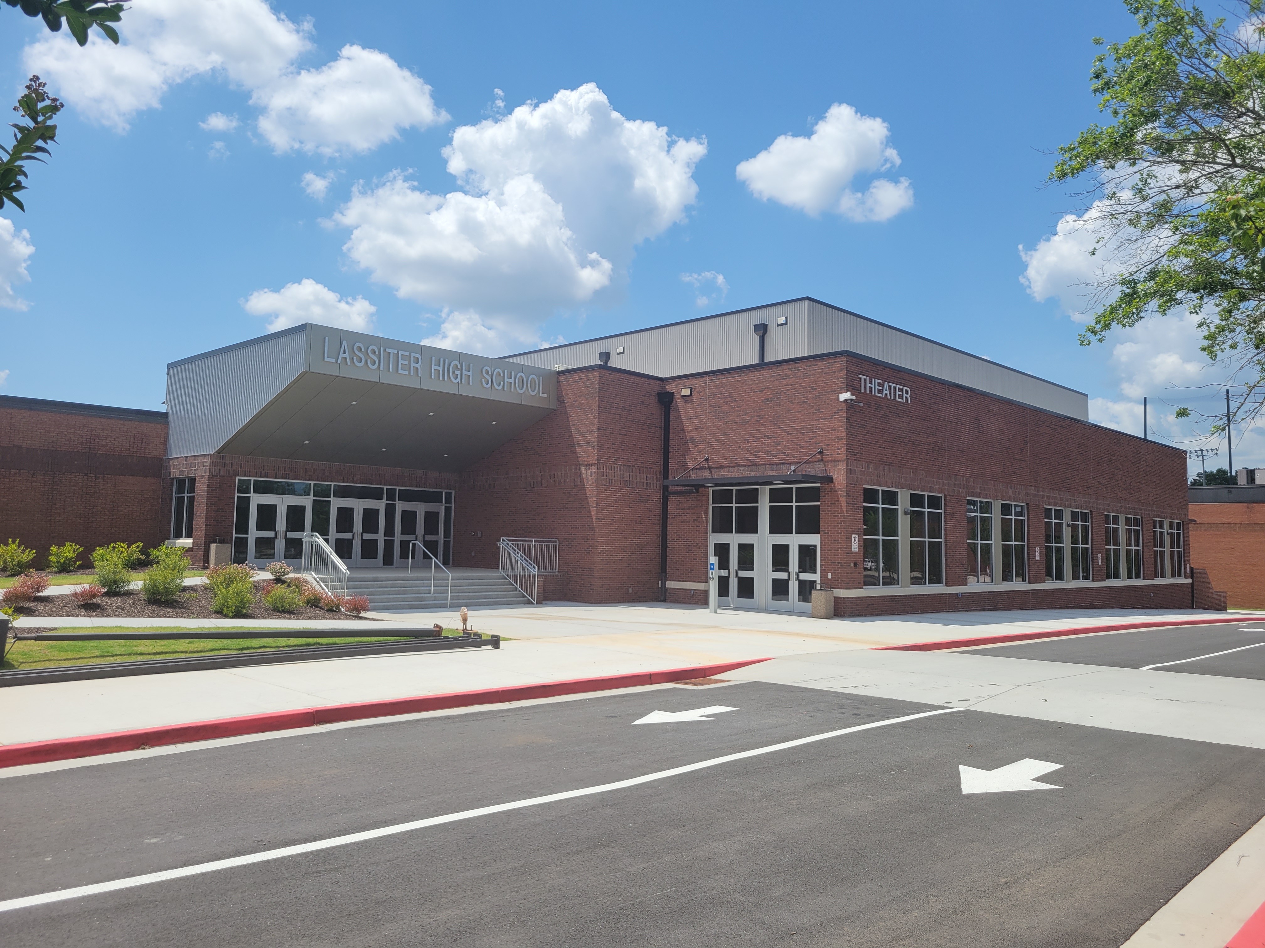 Brick exterior of Lassiter High School with a covered entrance and theater wing.