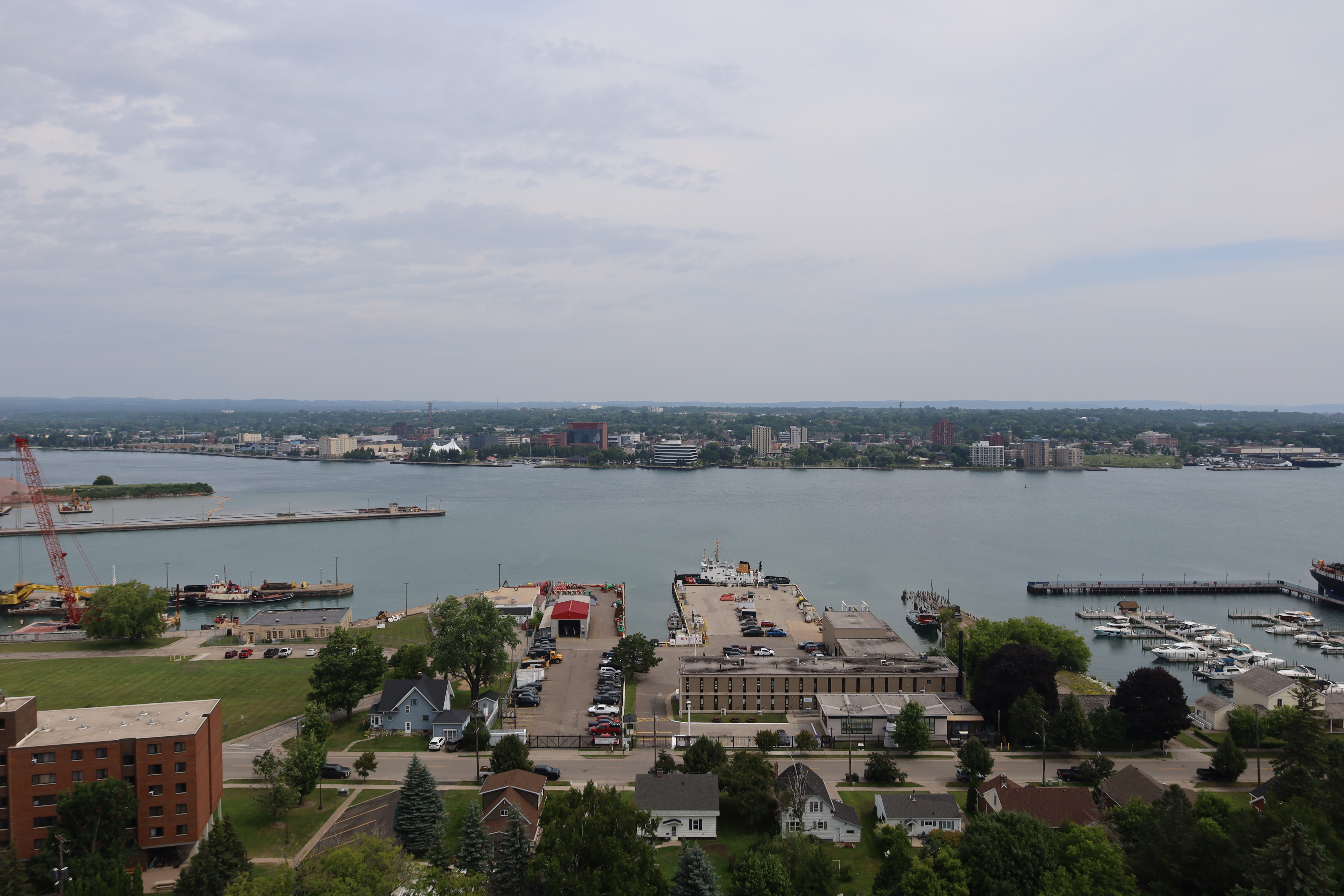 Elevated view of a harbor, marina, and waterfront buildings along a wide river.