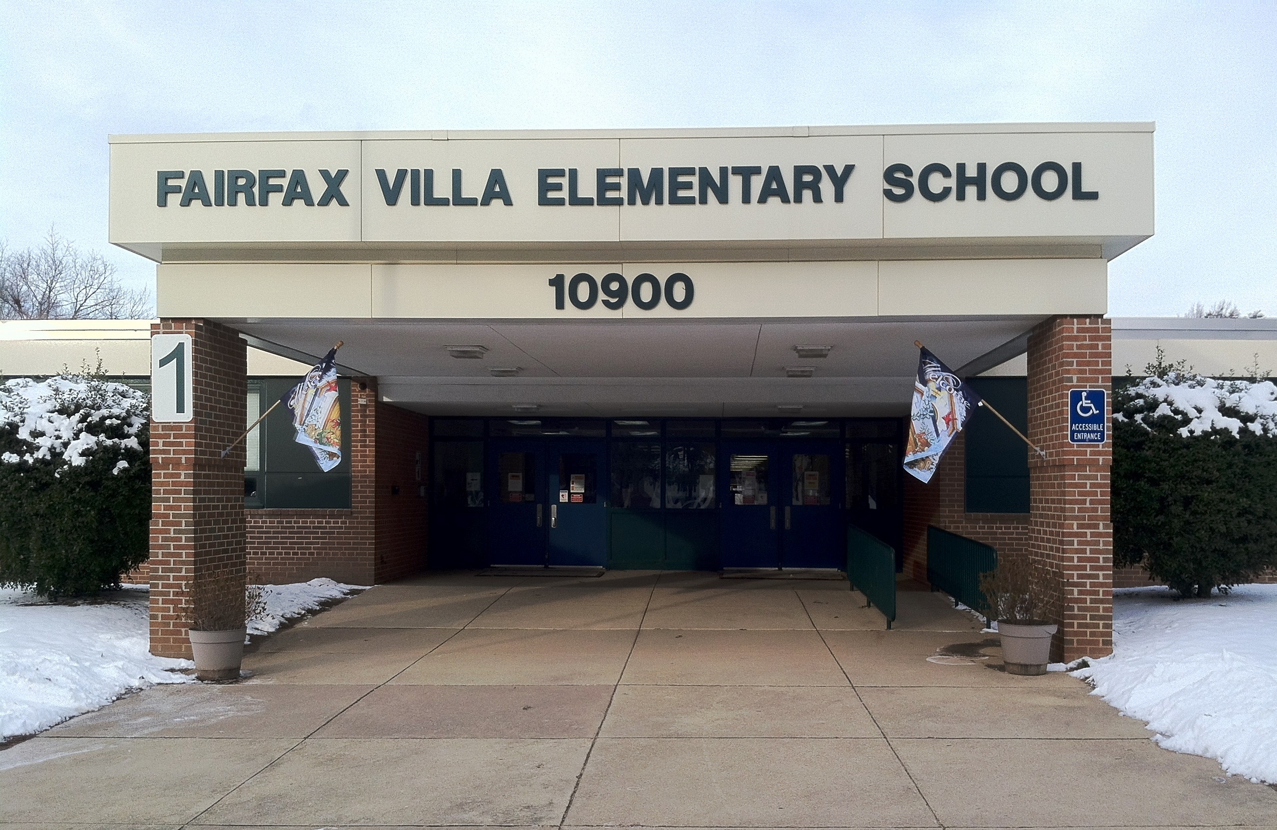 Brick entrance to an elementary school building with banners and snow on the ground.