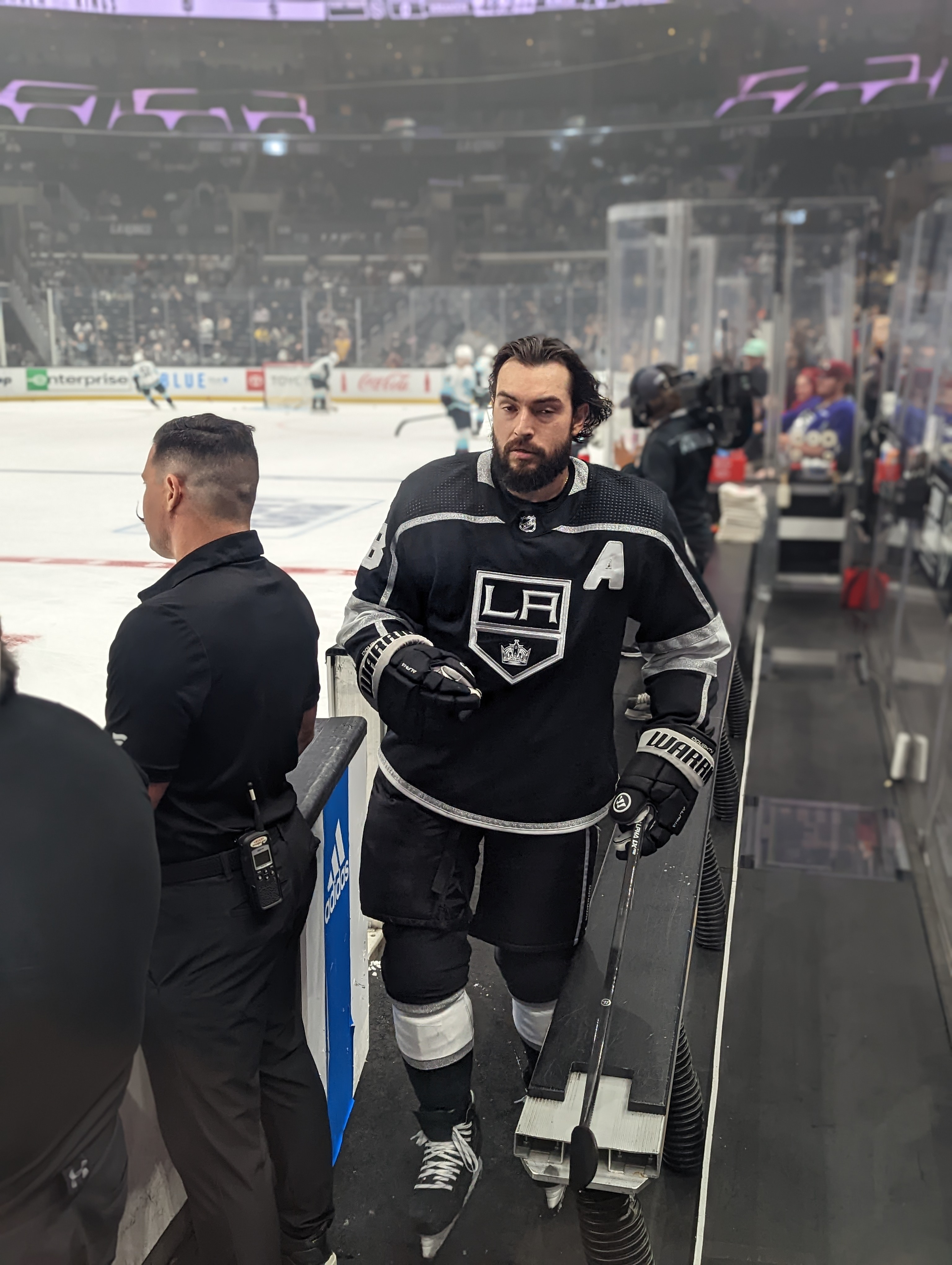 Hockey player in a black Kings jersey number 8 walking off the ice after warmups.
