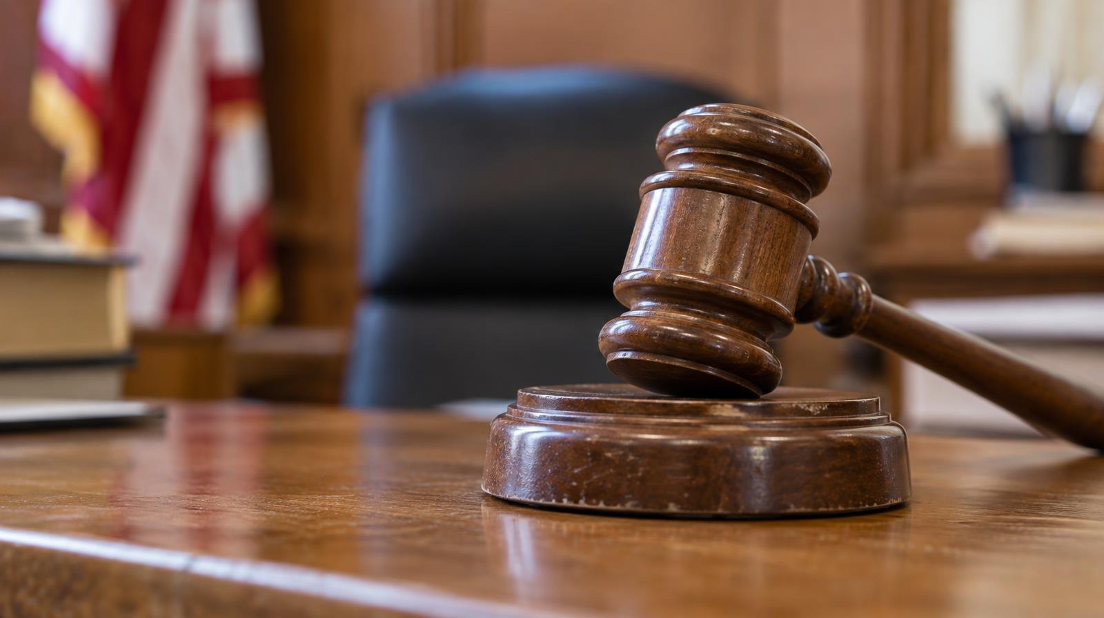 A wooden gavel resting on its sound block on a courtroom bench.