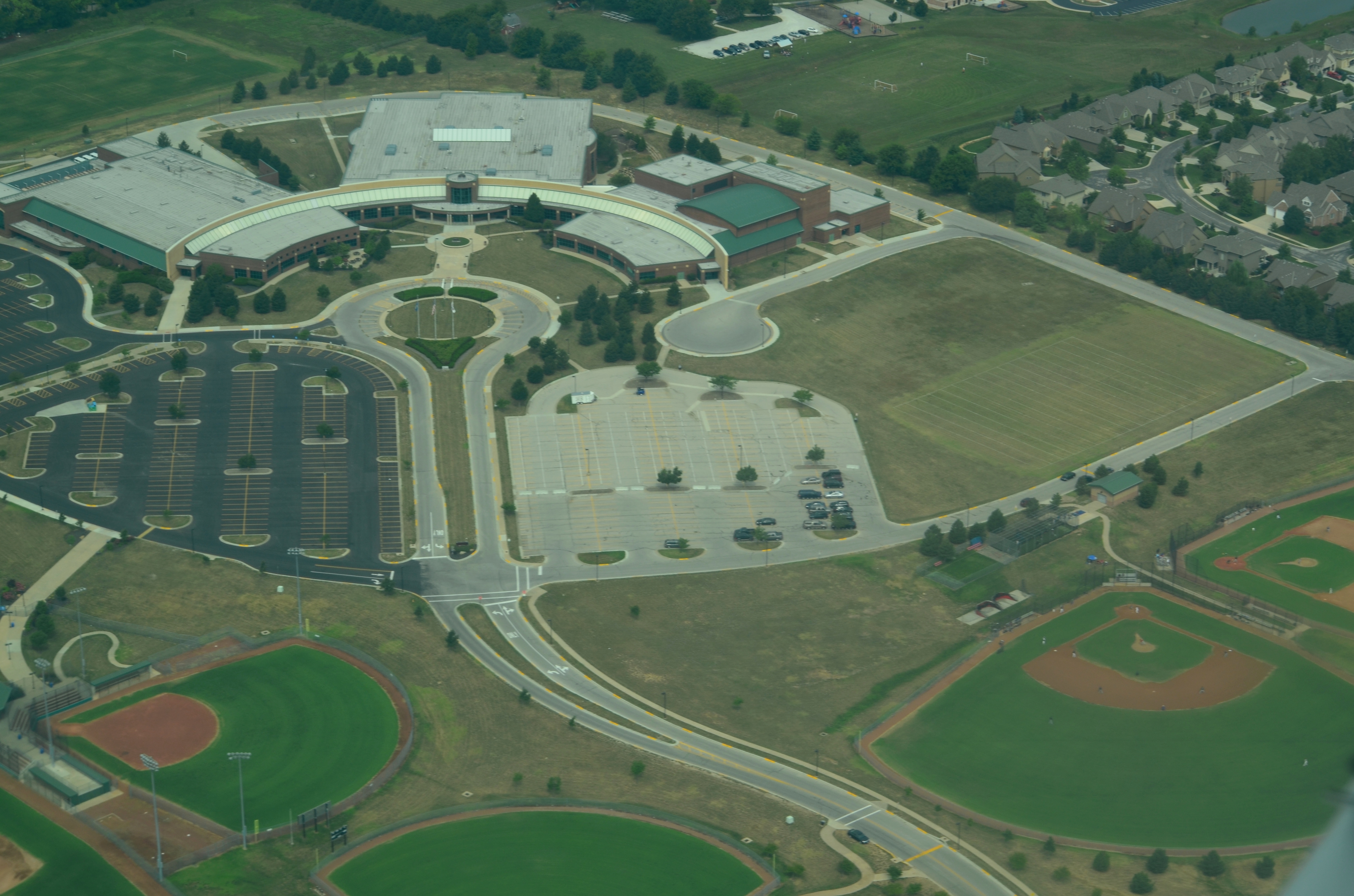 Aerial view of a large high school campus with parking lots and athletic fields.