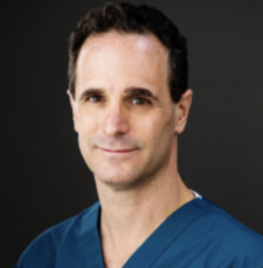Headshot of Gary Gechlik, an emergency medicine physician and Palo Alto City Council candidate, wearing blue medical scrubs.