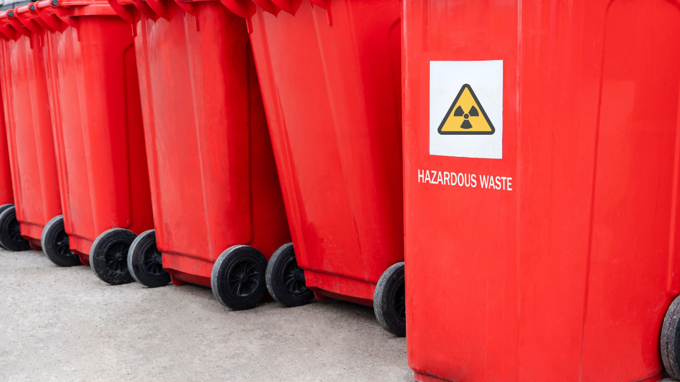 Red trash cans lined up to be filled with hazardous waste.