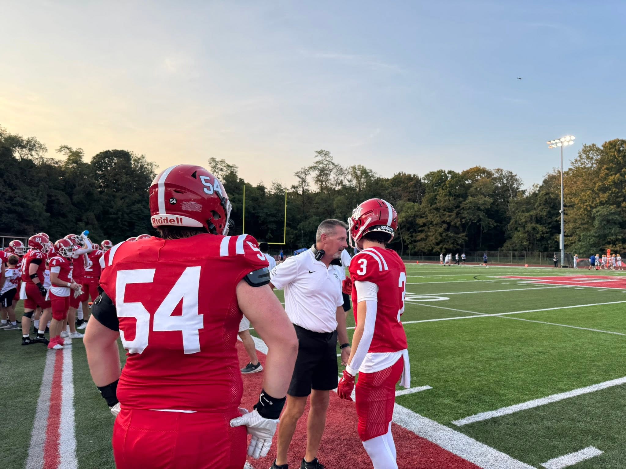 a coach and players on the indian hill braves football team