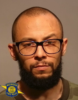 Joshua Grenier wearing black glasses, with a Michigan State Police emblem in the lower-left corner.