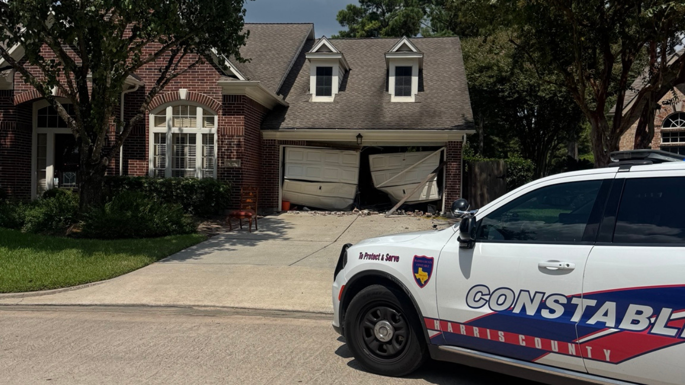 Brick home with damaged garage doors.