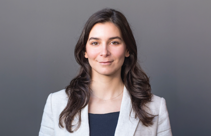 Alev Bilginsoy wearing a gray blazer against a gray background.
