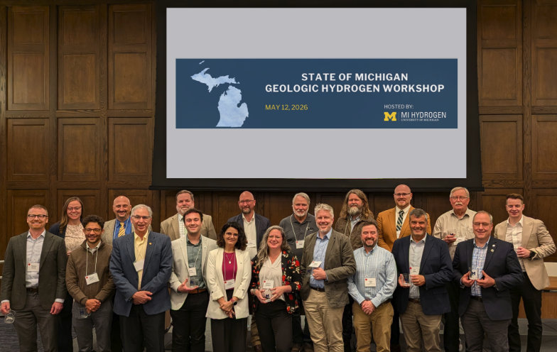 Attendees of the State of Michigan Geologic Hydrogen Workshop pose for a group photo in front of a screen reading "State of Michigan Geologic Hydrogen Workshop, May 12, 2026," hosted by MI Hydrogen at the University of Michigan.
