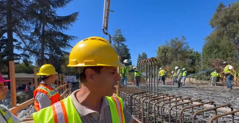 Construction workers in hard hats and safety vests at the Newell Road Bridge rebar and concrete pour site