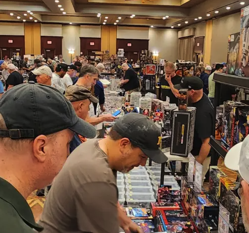 Vendors and collectors browse tables of toys and collectibles at a North Dallas Toy Show.