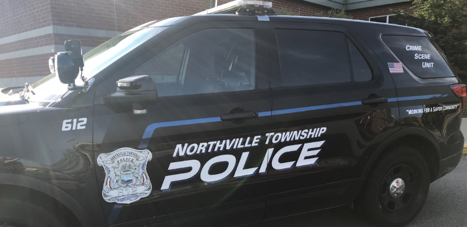 A black Northville Township Police SUV marked 'Crime Scene Unit' parked outside a building.
