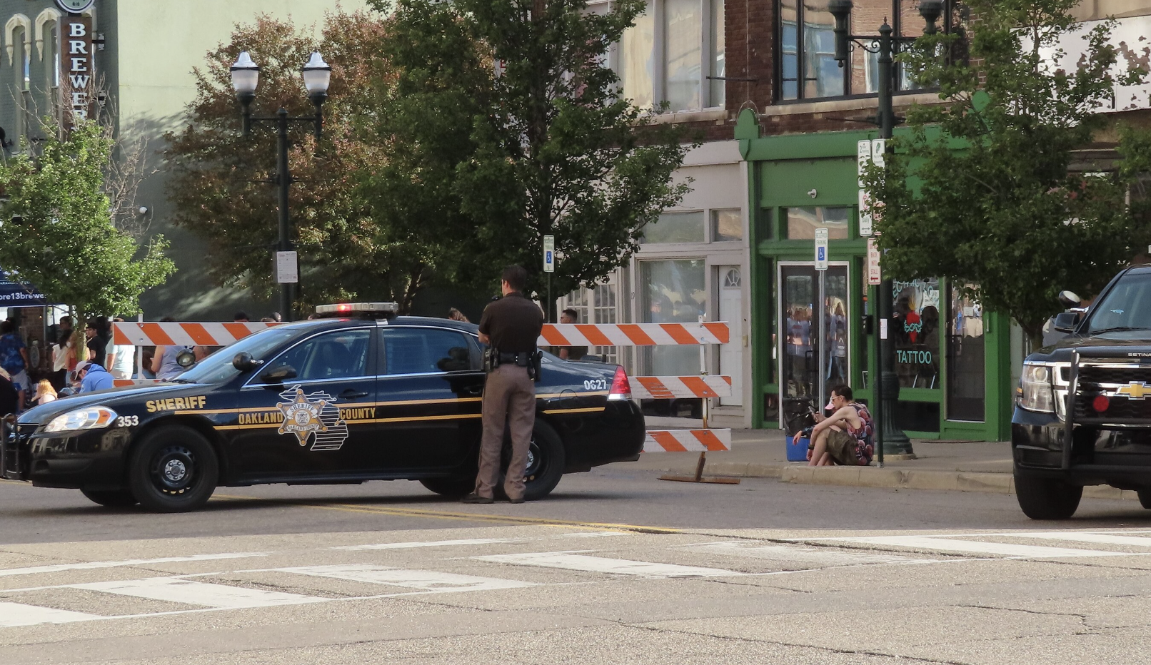 An Oakland County Sheriff's Office patrol vehicle and deputy on a blocked-off downtown street.