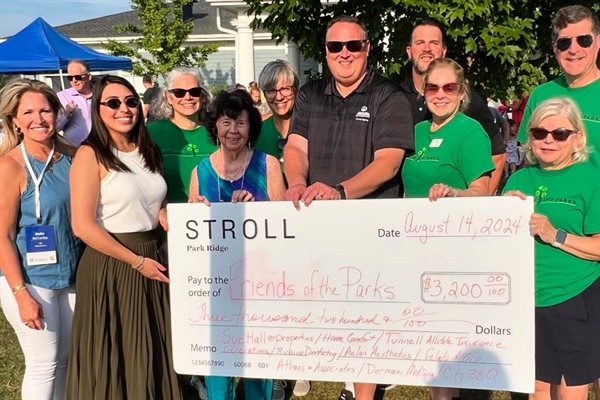 Kiwanis Club members hold up a ceremonial check