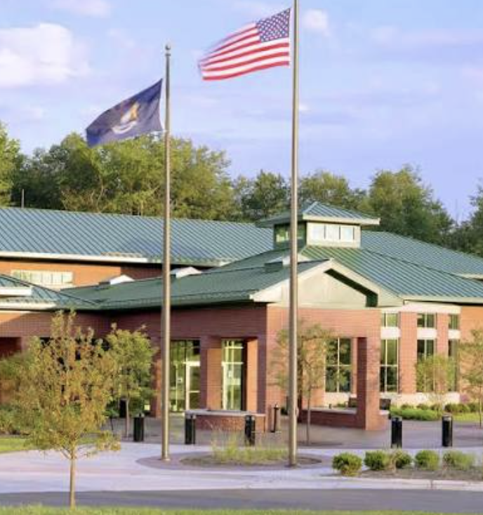 Plymouth Township Hall with American and Michigan flags flying outside the brick municipal building.