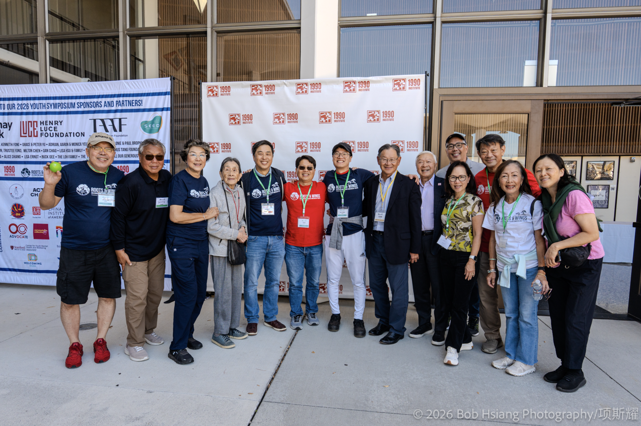 A group of speakers, mentors and organizers pose together outside the Roots & Wings Youth Symposium venue.