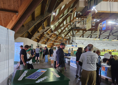 Runners and volunteers gather under the wood-beamed dome at a registration table during a past Run for Recovery event at the Superior Dome in Marquette.
