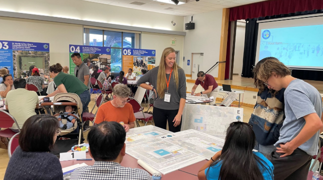 Residents sit at tables reviewing project boards and maps during a community workshop for the Dr. Martin Luther King Jr. Community Center renovation in San Mateo.