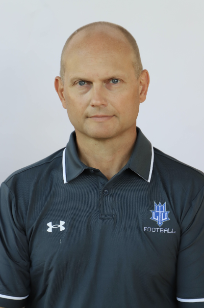 Headshot of Scott Merchant wearing a Lawrence Technological University Football polo, from his prior coaching role.