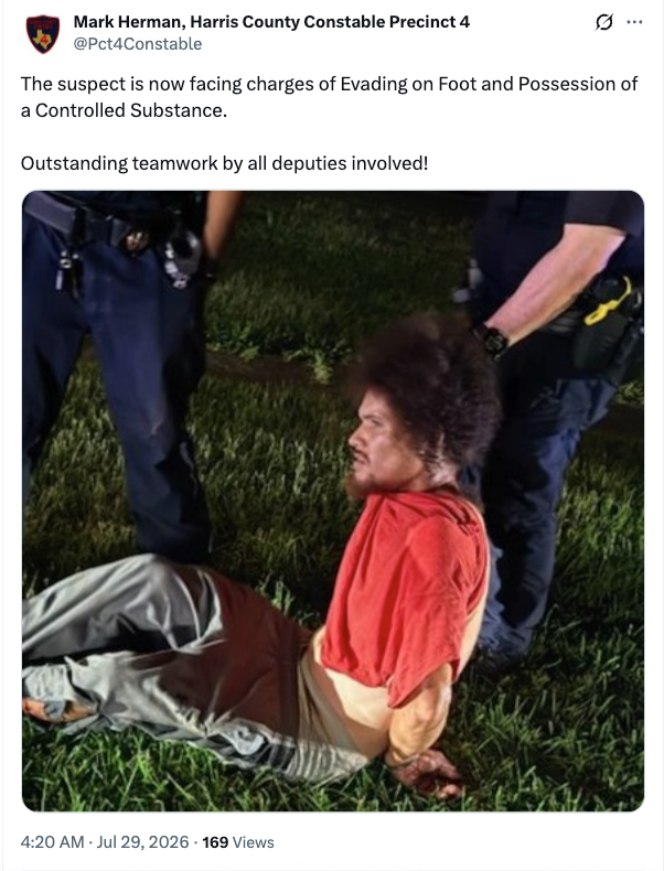 a man in police custody sitting on the ground