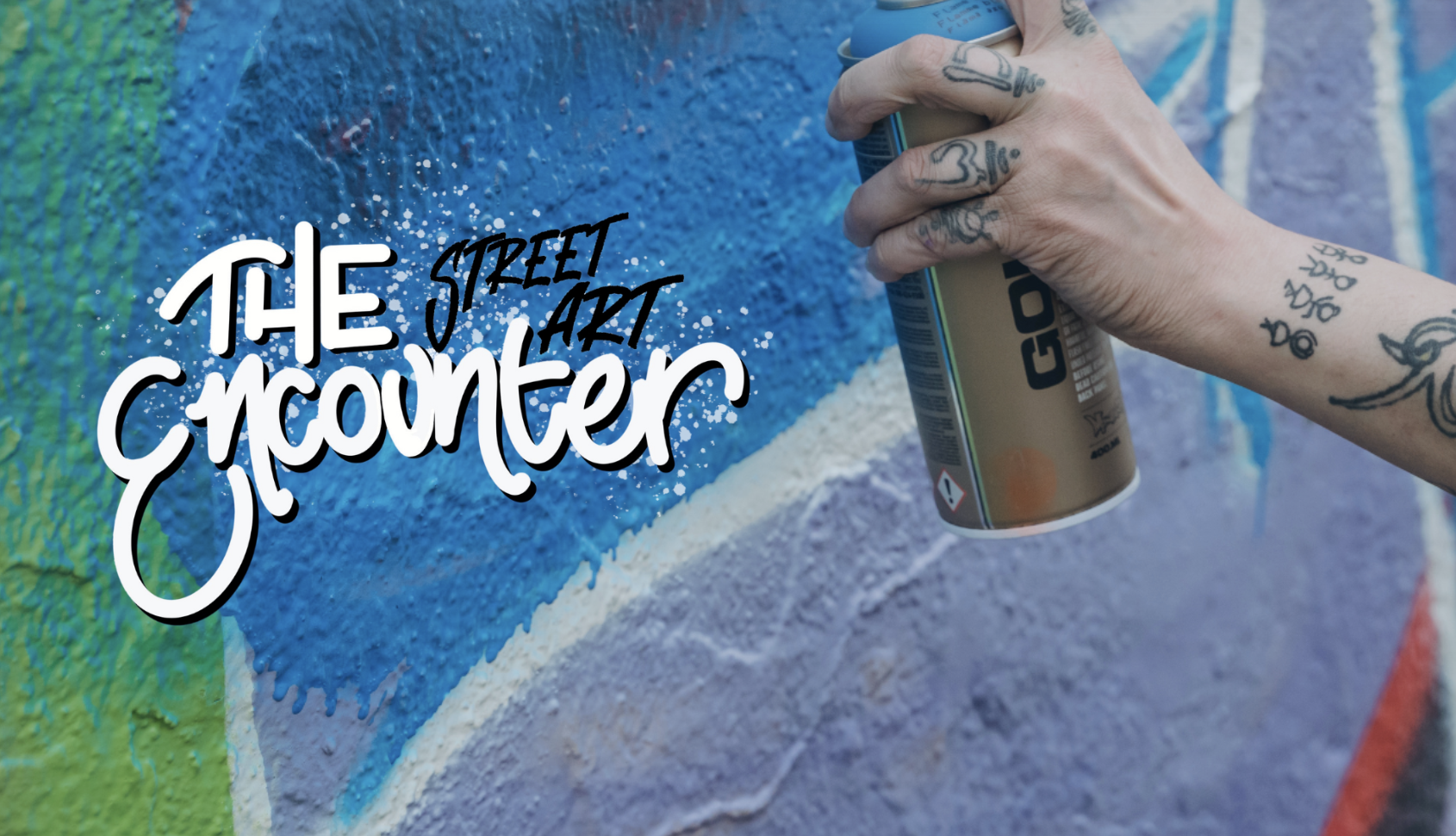 A tattooed hand holds a spray paint can against a blue mural wall, with "The Street Art Encounter" logo overlaid.