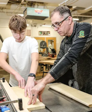 a man helps a student with a project