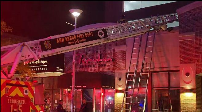 Ann Arbor Fire Department ladder truck and ladders outside Tomukun Noodle Bar during an overnight fire response on East Liberty Street.
