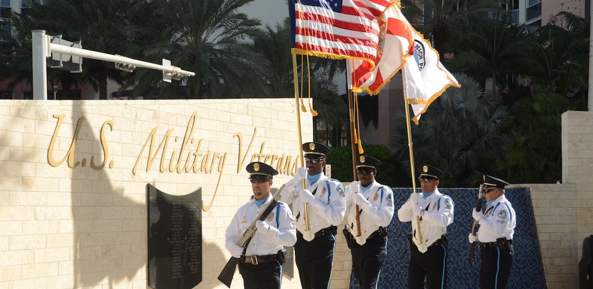 A color guard carries flags in front of the Veterans Wall at Heritage Park in Sunny Isles Beach in a city file photo.