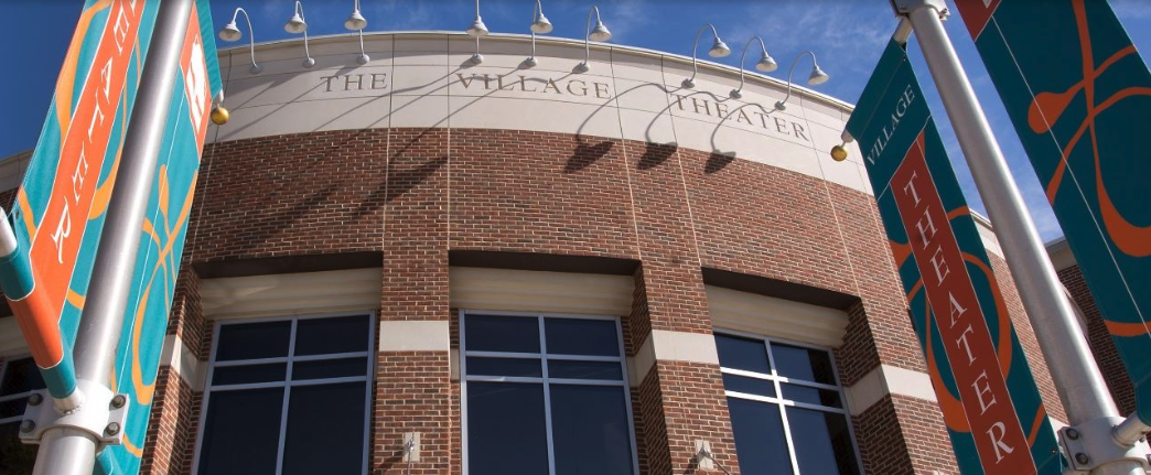 Exterior of the Village Theater at Cherry Hill in Canton, with promotional banners hanging out front.