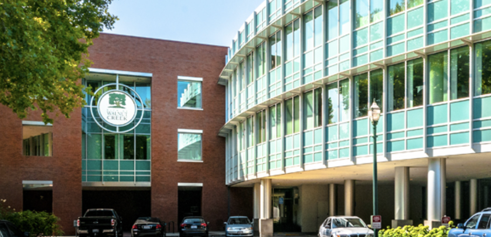 Exterior of Walnut Creek City Hall, a brick and glass municipal building with the city seal on its facade.